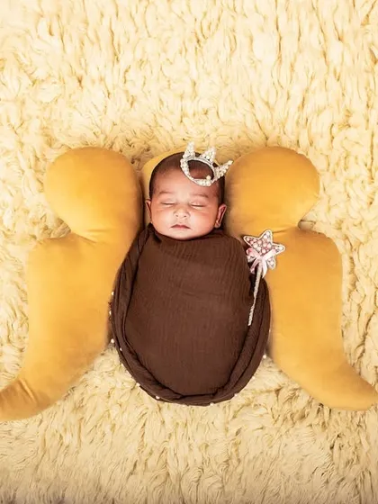 Your little angel. This newborn portrait uses soft angel wings, a tiny crown, and a magic wand prop to create a sweet and whimsical image.
