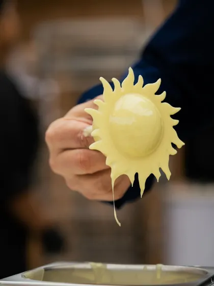 A sun-shaped white chocolate garnish, showcasing creative molding techniques.