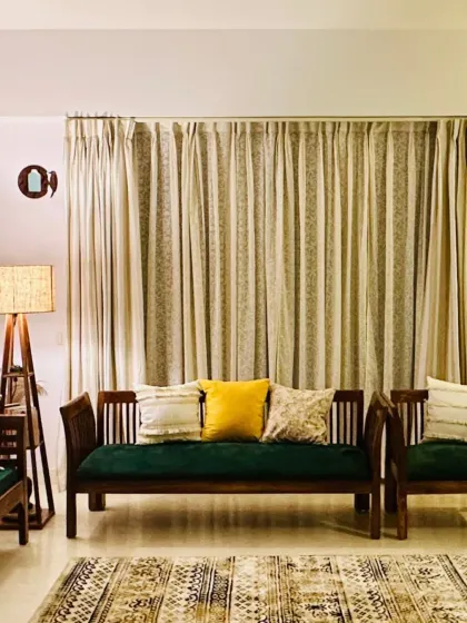 A full view of this elegant living room, showcasing how our neutral-toned curtains provide a sophisticated backdrop for the dark wood and green velvet sofa set.