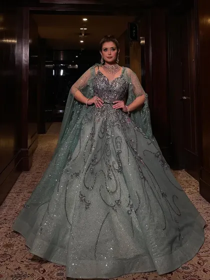 A powerful stance in our mint organza gown. The added cape gives this sparkling ball gown an extra layer of drama and sophistication, perfect for a bride who wants to feel like a queen.