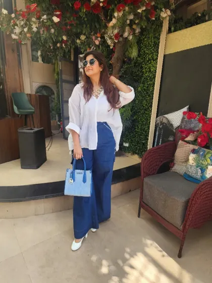 The full look, accessorized with a statement necklace and a light blue handbag, turning heads at a stylish soiree.
