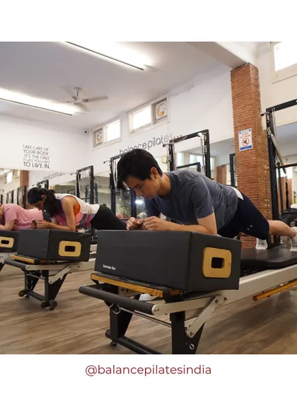 A group of clients holding a strong plank on the box. The concentration is palpable.