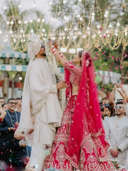 The fun and excitement of the varmala ceremony, with guests showering the couple in petals. I capture the energy of the crowd to tell the full story.