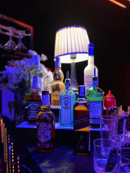A well-stocked bar is key to any great party. This image shows a selection of premium spirits against the backdrop of our neon-lit setup, ready to be mixed into any cocktail your guests desire.