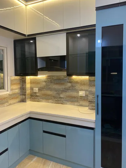 A closer look at the cooking area, showing the built-in chimney and the textured tile backsplash.