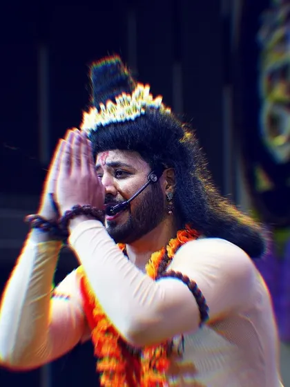 A close-up of my expressive performance as Narada Muni, with a headset mic ensuring my voice is heard clearly throughout the devotional act.