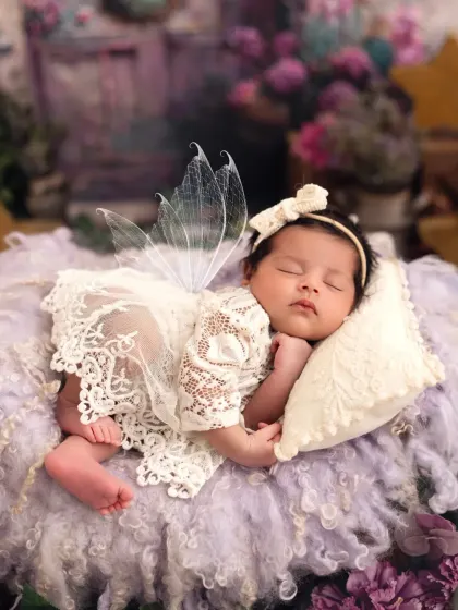 A close-up of the sleeping fairy baby, showing the delicate lace outfit and her peaceful expression.