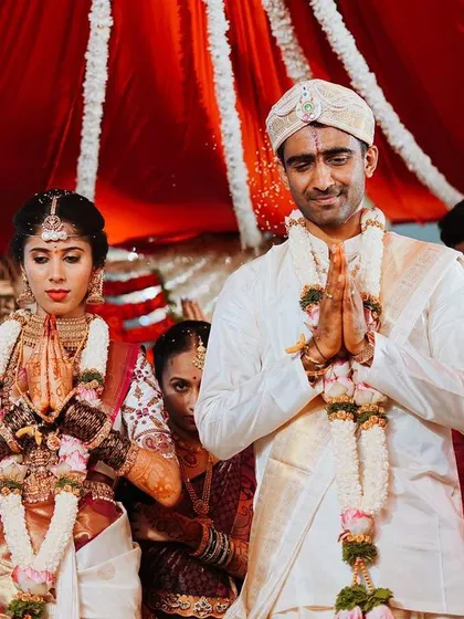 A candid shot of the bride and groom during their wedding ceremony, sharing a moment of prayer and reflection together.