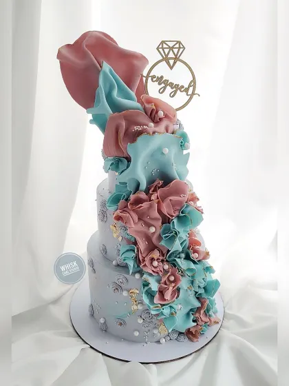 A modern and quirky engagement cake for the bold and rebellious couple. This design features abstract shapes, contrasting colors, and an edgy, artistic flair.