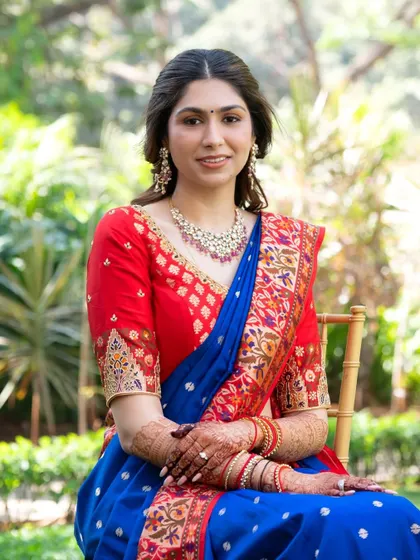 A stunning portrait of Stuti. Her makeup is effortlessly elegant, paired with a beautiful blue and red saree for a timeless look.