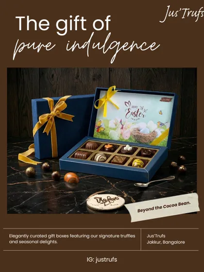 Our Easter 2026 gift box holds assorted chocolates beneath a seasonal illustrated lid, with a dark outer box and gold ribbon.