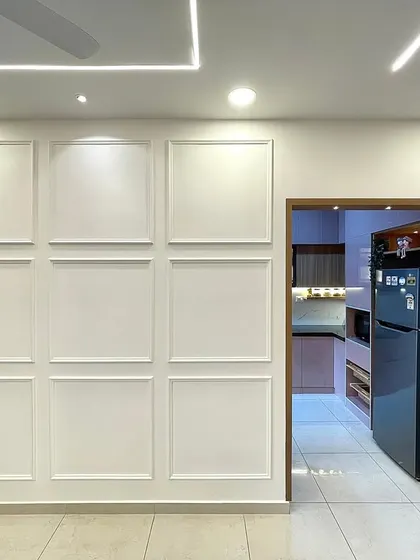 A simple yet effective design choice, the white paneled wall adds architectural interest and elegance to the space, creating a clean backdrop that allows the furniture and decor to stand out.