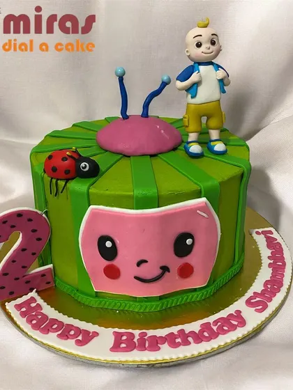 A vibrant Cocomelon cake featuring JJ and the iconic watermelon logo. The bright green and pink design is perfect for a second birthday party full of songs and fun.
