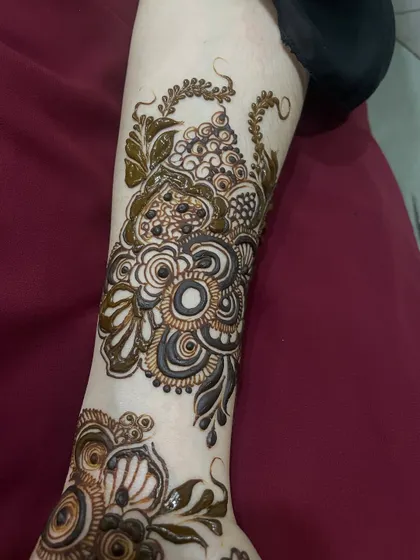 A beautiful floral and vine composition on the arm, typical of the elegant Doha and Gulf styles.