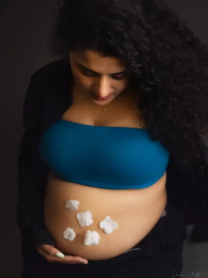 A creative and sweet way to announce a baby boy. The little cotton flowers on the baby bump are a delicate touch in this modern, casual maternity portrait.