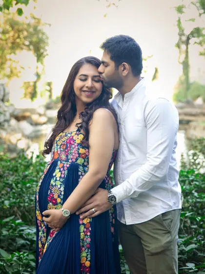 A tender forehead kiss in a lush garden setting. These simple gestures of love make for the most heartfelt and timeless couple maternity portraits.