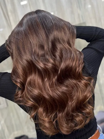 The back view of this mocha brown style, showcasing the depth and dimension of the color in long, flowing waves.