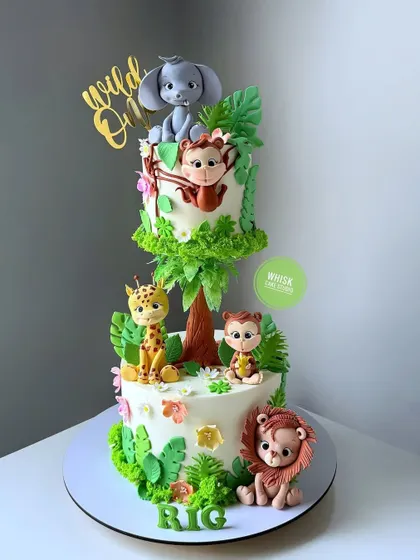 A "Wild One" jungle-themed cake that uses buttercream as a base with fondant animal accents. This is a great technique for those who prefer less fondant.