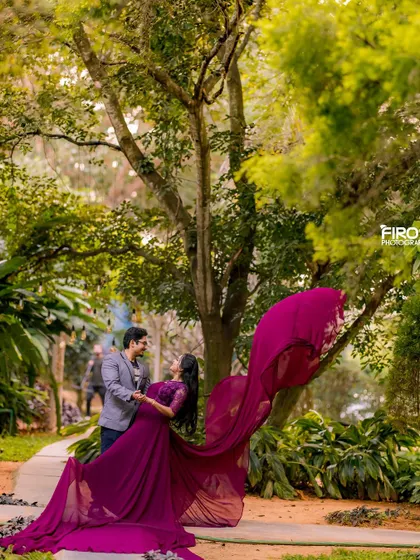 A candid moment of dance and laughter in the middle of a lush garden path. The flowing magenta gown adds a splash of vibrant color and movement to this romantic portrait.