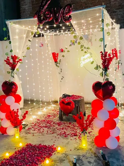 Another view of the romantic cabana setup. This angle shows the heart-shaped balloons and the cozy arrangement inside the canopy, which is decorated with hanging photos for a personal touch.