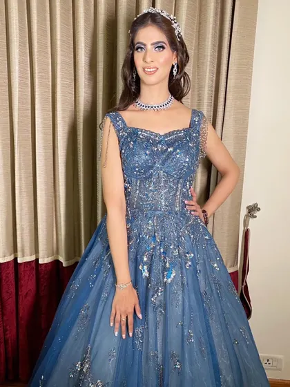 Dr. Srishti is absolutely killing it in this blue gown for her cocktail party. The makeup features a silver and blue cut-crease eye look.