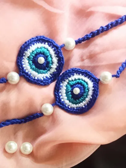 A detailed look at our evil eye crochet rakhis, embellished with pearl beads. These are crafted to be a stylish and meaningful accessory that wards off negativity.