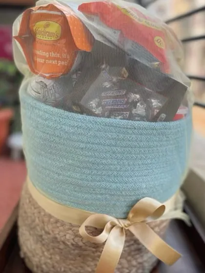 A basket full of goodies, beautifully wrapped and ready for dispatch. This gift contains a variety of savory and sweet snacks, making it a versatile and well-loved option for casual corporate gifting.