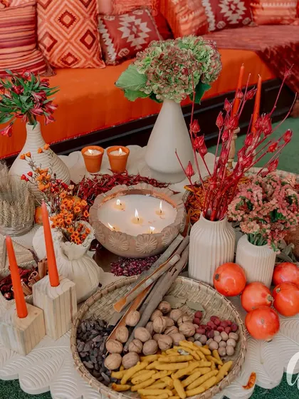 The coffee table decor was a feast for the senses, combining flowers, candles, and edible elements like walnuts, pomegranates, and turmeric root. This creates a feeling of warmth, welcome, and abundance.