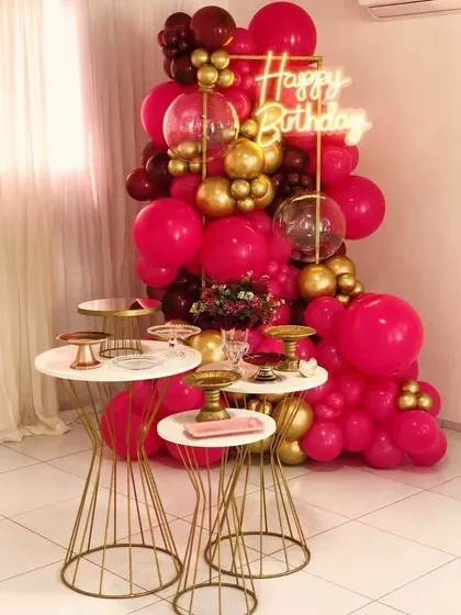 Bold and beautiful. This party decor makes a statement with a dramatic balloon arrangement in hot pink and gold, perfect for someone who loves a touch of glamour and vibrant color.