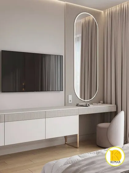 A bedroom with a TV and dressing table unit featuring a fluted texture and an elegant, backlit oval mirror.