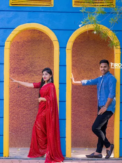 A fun and stylish pose in a colorful architectural setting. The couple's coordinated outfits and their confident stances create a very modern look.