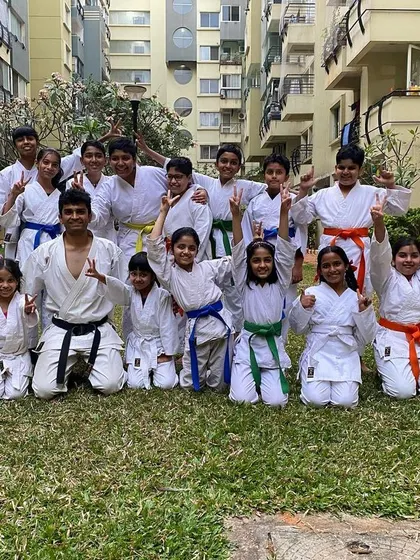 An energetic group photo with students from our Purva Belmont dojo celebrating their newly earned belts with their Sensei.