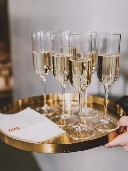 A server holds a tray of champagne flutes, ready for a toast.
