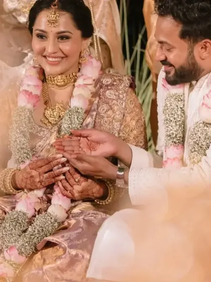A sweet moment where the groom holds the bride's hand during their wedding ceremony.