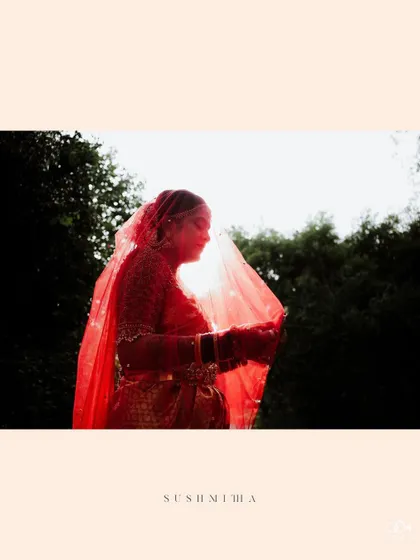 A stunning silhouette of the bride against the sun, her red veil glowing beautifully, creating a magical and ethereal portrait.