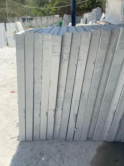 A stack of uniform, machine-cut Bangalore stone slabs.