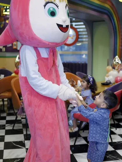 Masha holds hands with a happy birthday boy. These gentle and fun interactions make our character appearances a hit with younger children.