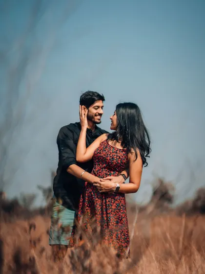 An intimate pre-wedding portrait in a field of tall grass. We use natural elements to frame you, creating a sense of privacy and romance in your couple photos.