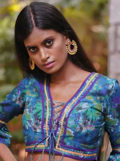 A bohemian-style floral blouse is paired with simple gold hoop earrings for a relaxed, chic look.