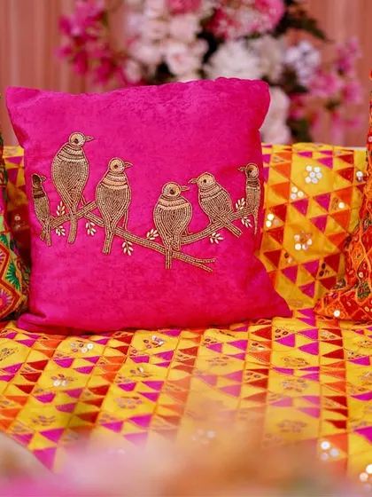 A close-up of the custom cushions used in the decor. We used a mix of fabrics, from velvet with bird embroidery to traditional Phulkari with mirror work, to add texture and authenticity.
