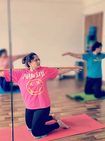 A student using a stick for support and alignment in a kneeling twist during our Danda Yoga workshop.