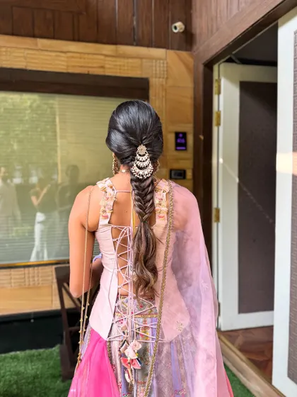 The back view of a gorgeous fishtail paranda braid. The pearl accessory at the top adds a touch of elegance, while the long, flowing braid gives that classic Indian bridal feel.