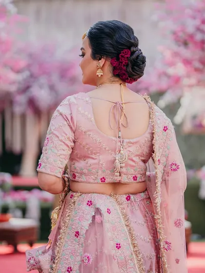 A perfect bun for a bride who dreams of a touch of nature's grace. I used these beautiful deep red flowers to create a classic floral bun that stands out against her pink lehenga.
