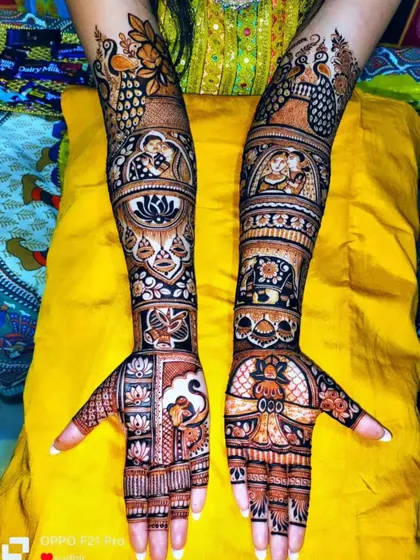 A complex design featuring multiple traditional elements, including peacocks, lotus mandalas, and couple figures, creating a rich tapestry of art.