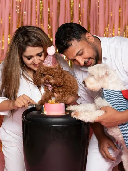 A birthday is a family affair. Here, the pet parents join in to help their toy poodle cut the cake, creating a heartwarming memory of the celebration they shared together.
