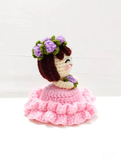 A side view of the reversible flower doll keychain.