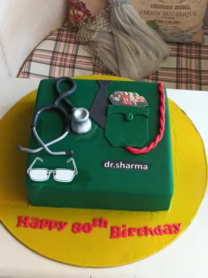 A professional and respectful cake for a doctor's 80th birthday, designed to look like a green scrub shirt with a stethoscope.