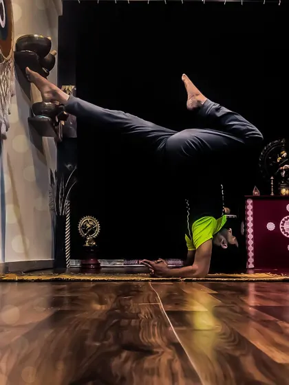 My morning practice often includes Pincha Mayurasana, the feathered peacock pose. Using the wall as a guide, I work on the split-leg variation to open my hips while building shoulder and core strength.