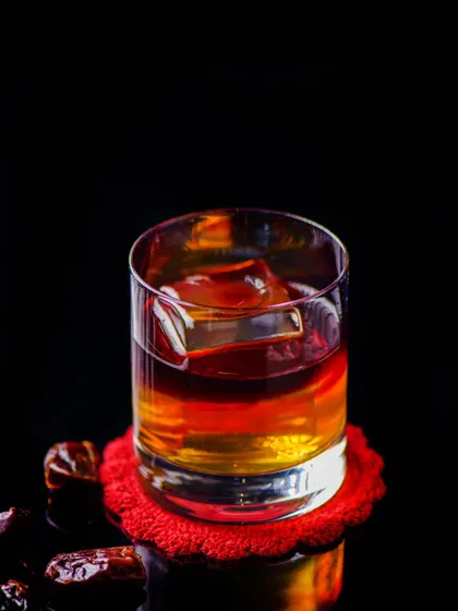 A classic whiskey on the rocks, with a large, clear ice cube that melts slowly, ensuring your drink is never diluted. A timeless choice.
