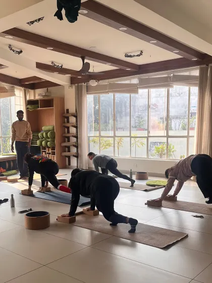 A class works on a plank variation, building core strength with the guidance of an instructor.